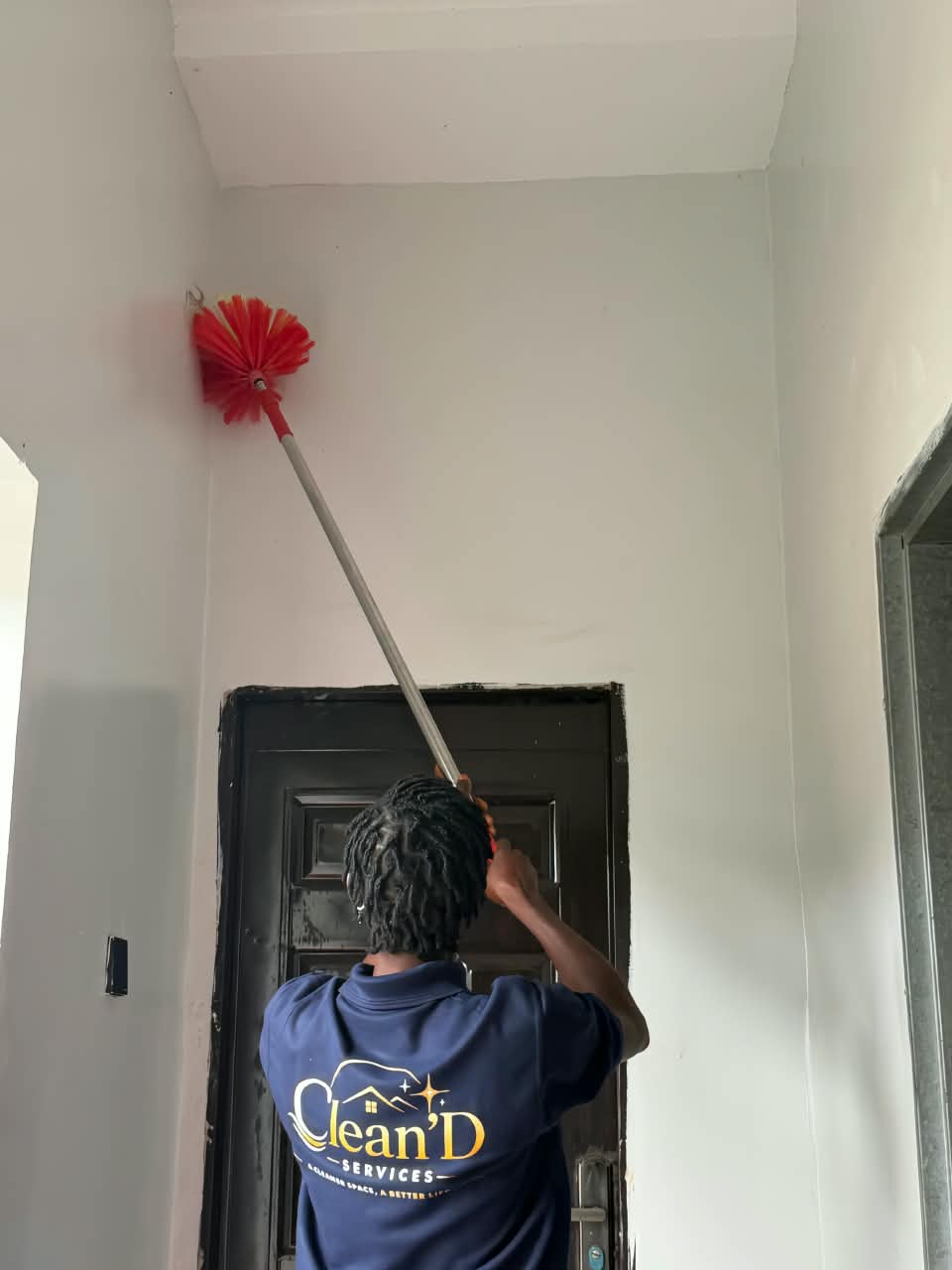 A worker cleaning cobwebs